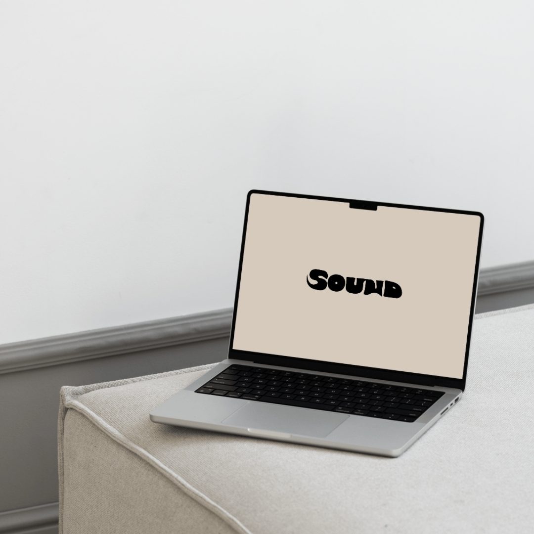 Ein MacBook auf einem Sessel. Das Display zeigt das Logo von Arie Rize auf schwarzem Hintergrund.