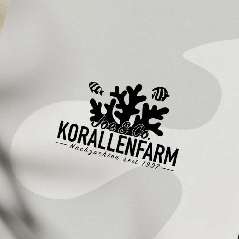 Ein Papier zeigt das Logo von der Korallenfarm in schwarz.